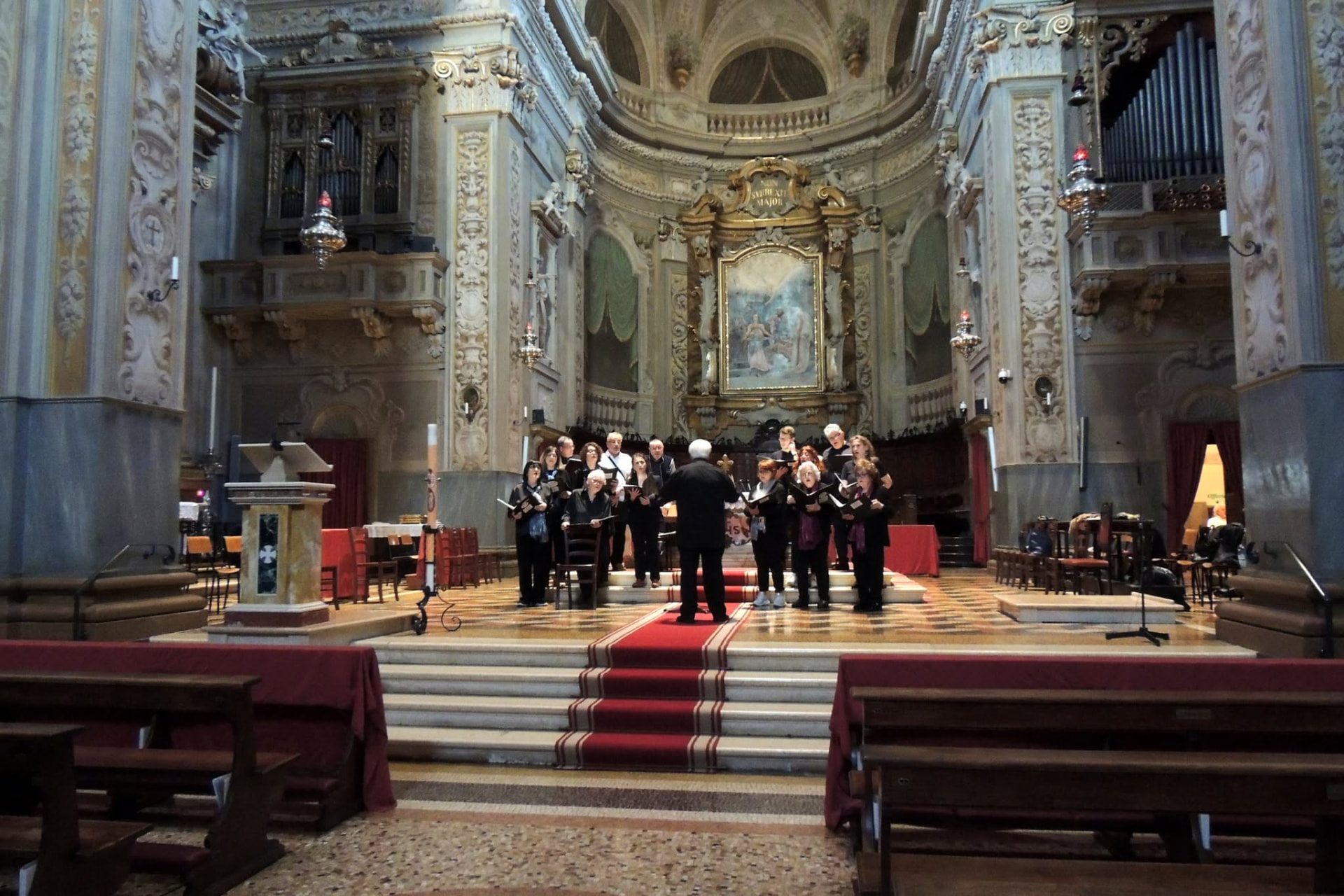 Il coro in concerto nella chiesa barocca, sul podio davanti all'altare maggiore